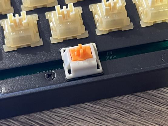 A white and orange Duhuk magnetic switch installed into the spacebar socket.