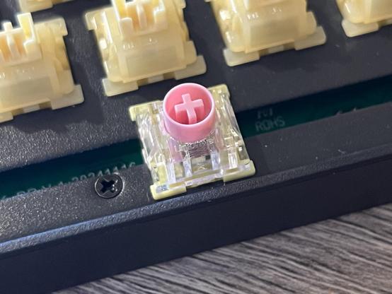 A clear and pink Unionwell Ultra magnetic switch plugged into the spacebar socket of a mechanical keyboard.