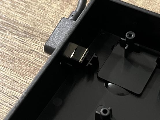 A USB C cable poked through the side of a keyboard enclosure, showing where the USB Type-C port would be. A little plastic backstop helps reinforce the socket.