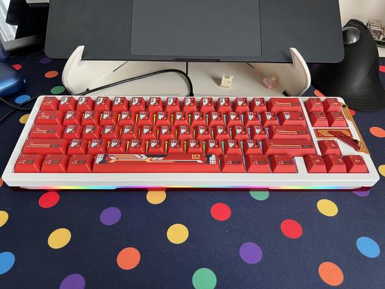 A mecha styled white, red and yellow mechanical keyboard in a 65% layout with a 2x2 key cluster on the right.