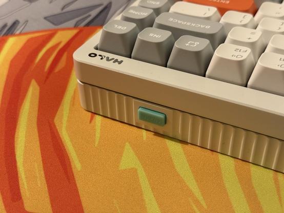 The tip of the USB dongle poking out of the back of its storage in the keyboard. It is also, you guessed it, teal.