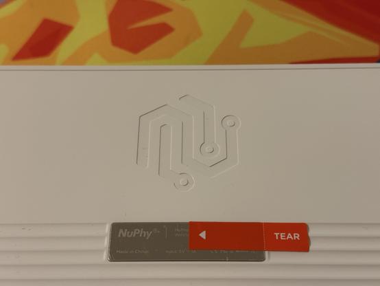 A simple circuit-trace like, debossed logo on the back of a white mechanical keyboard.