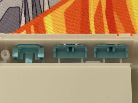 The USB-C plastic shroud and the two rear switches, all colour-accented teal.