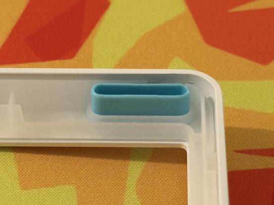 A teal blue shroud intended to keep the little accent LEDs in the top corner of the keyboard from bleeding out into the keybed and side-lights.
