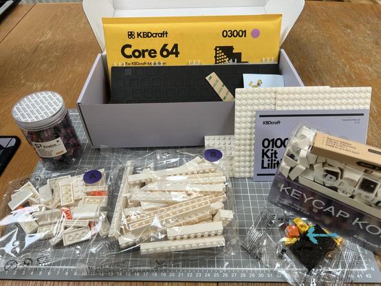 A KBDCraft Lilith 60% ISO keyboard kit, unassembled and in a variety of bags, boxes and tubs- the pieces include the LEGO-like bricks to assemble the outer case, two boxes of keycaps, stabilisers, switches, PCB and more.