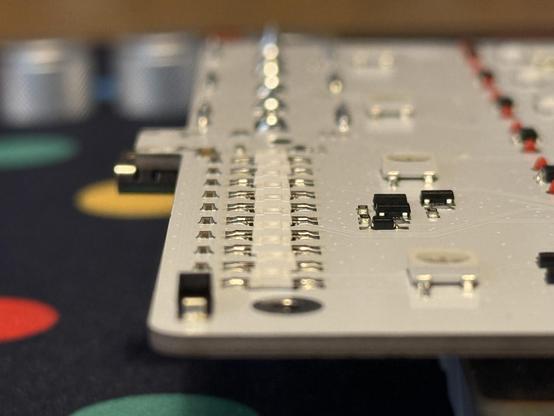 Awkward blurry side-on shot of the PCB showing a densely packed row of 10 reverse mount RGB LEDs.