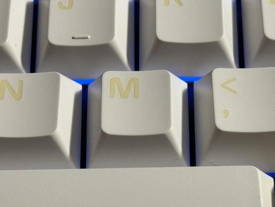 A closeup of an M key showing the legend slightly bulging out.