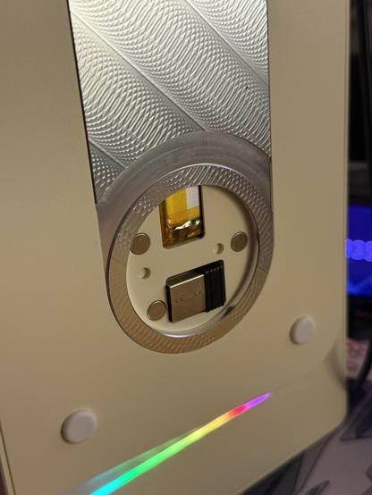 Closeup of the bottom of the keyboard showing a circular recess where the USB dongle is stored.