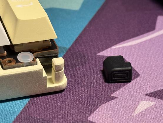 A big rubber corner bumper/gasket removed from its tall metal post and set aside.