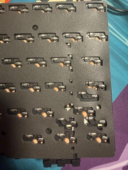 A slightly busy cluster of hotswap mechanical keyboard sockets on the reverse of a PCB. Two sockets face each other like a yin/yang, intended for the stepped caps lock, the only option supported by the plate.