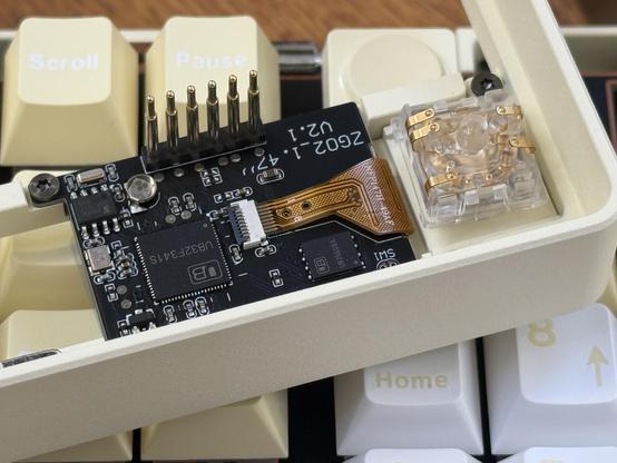 An LCD module with six pogo pins. Next to an encoder with five leaf sprung copper pins.