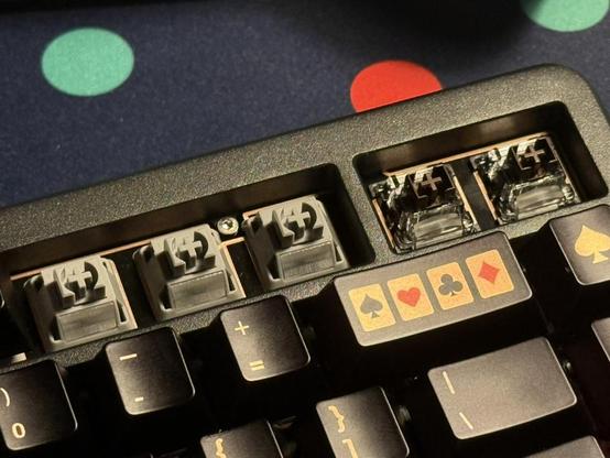 A mechanical keyboard with some keycaps removed revealing a mix of different coloured mechanical and magnetic switches.