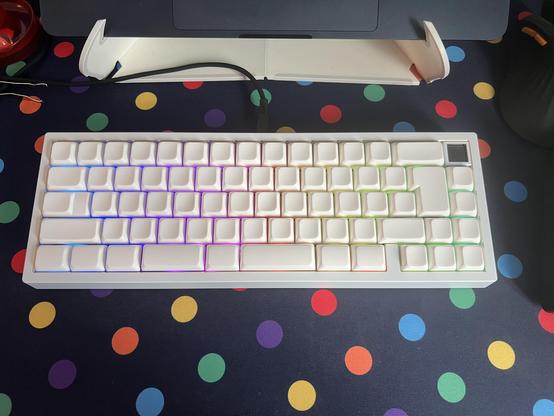 A compact keyboard populated with plain white keycaps with a soft, low, rounded profile. The spacebar is split and the caps lock is stepped.