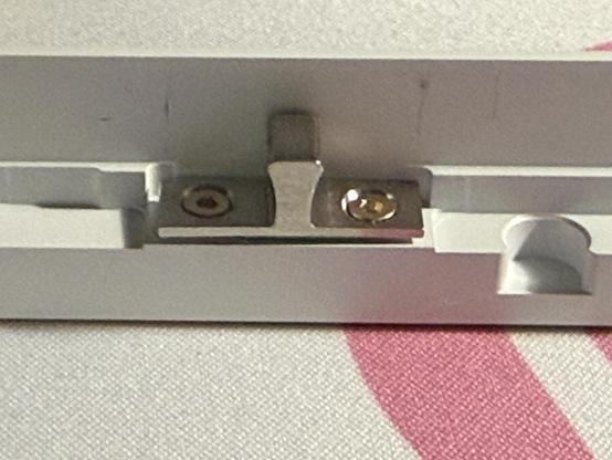 A keyboard ball catch shimmed up slightly by tape.