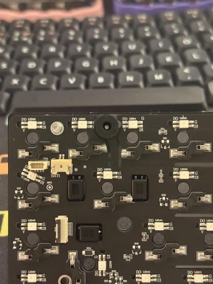 The reverse of the keyboard PCB showing a sprinkling of connectors and a slightly curved cantilever routed out between two hotswap sockets.