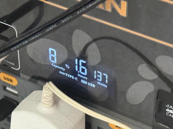 Close up of a low-fi segment style LCD display showing 8% battery capacity, 1.6 hours to charged and 137watts input.