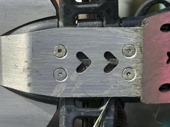 The metal skid plate, scratched and dinged with some very sorry looking screw heads.