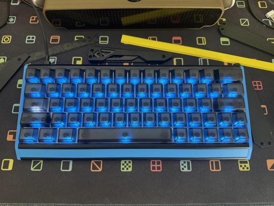 A customised IQUNIX EV63 with electric blue 3D printed parts replacing the long front “chin” badge and the left/right end caps.