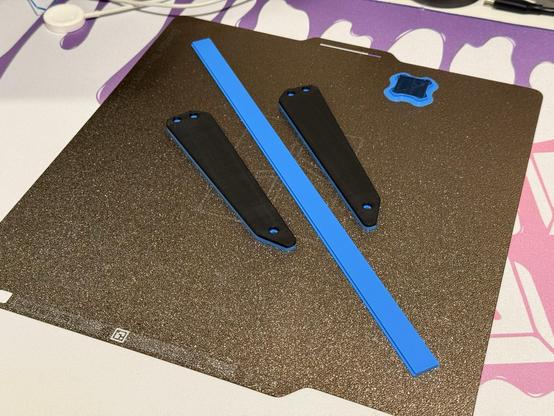 Some 3D printed replacement keyboard parts lying on a print plate.