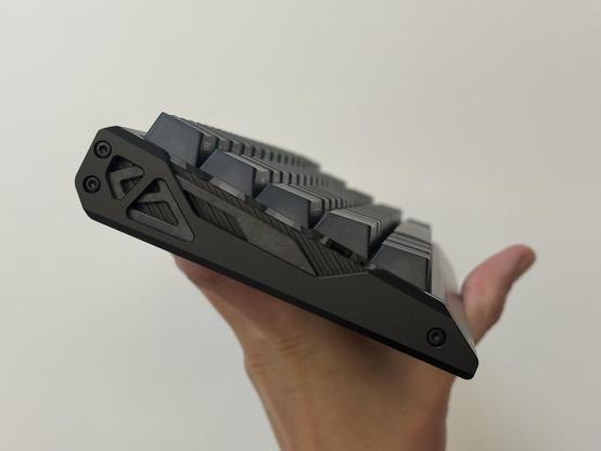 The side of the keyboard with cut aways showing an inter carbon fibre derail and a diagonal grooved piece under that.