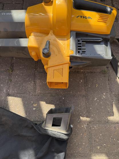 The vacuum bag removed from a garden leaf shredder. The plastic clip engages with an internal switch to ensure it can only work with the bag in place.