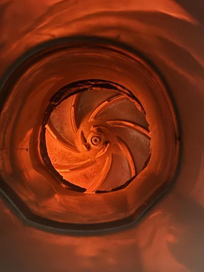 The dimly illuminated orange tube looks almost like the throat of some horrid creature, and the shredder blade almost natural in its spiral symmetry.