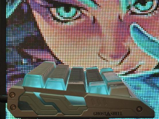 A pixelated rendering of a woman with vibrant green eyes looks over the EV63 shell core keyboard.
