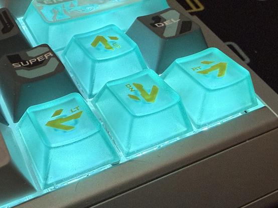 Four translucent arrow keys brightly lit with a blue green backlight.