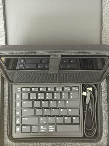 An 8” LCD and two halves of a low profile chiclet split keyboard packed nearly into a carry case.