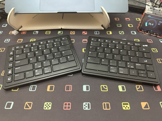 Two halves of a very flat, very thin split keyboard.